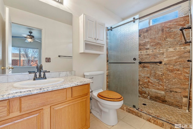 bathroom featuring ceiling fan, tile patterned floors, toilet, vanity, and a shower with shower door