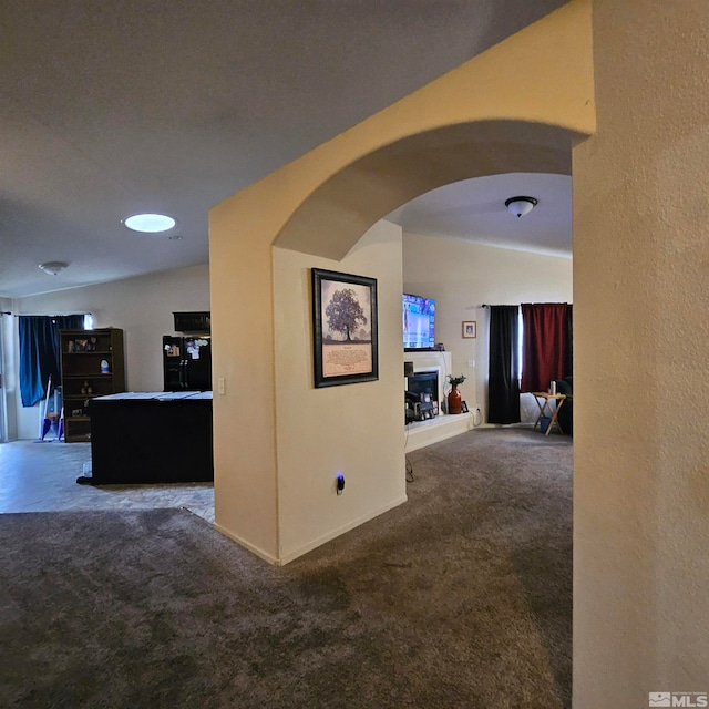 corridor with carpet flooring and lofted ceiling