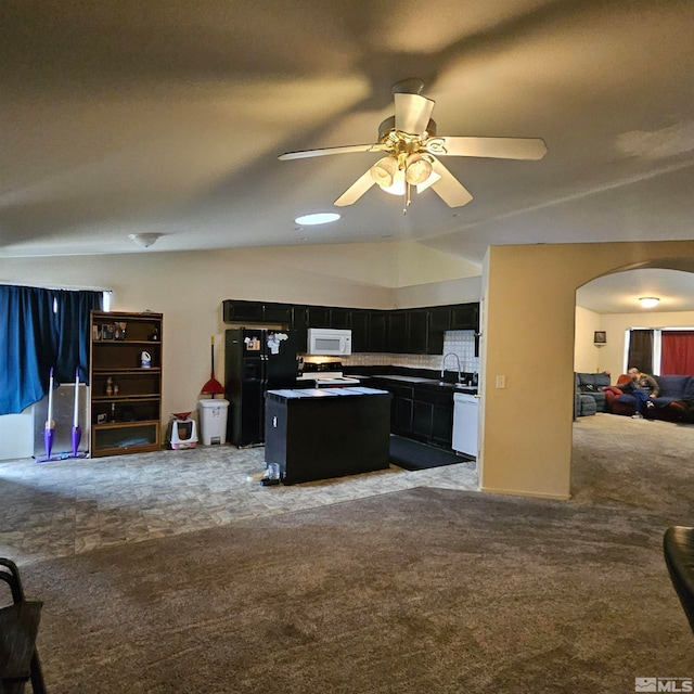 kitchen featuring carpet flooring, backsplash, white appliances, ceiling fan, and a center island