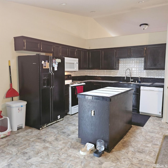 kitchen with lofted ceiling, backsplash, white appliances, sink, and a kitchen island