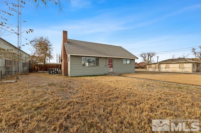 view of front of property with a front lawn and central AC