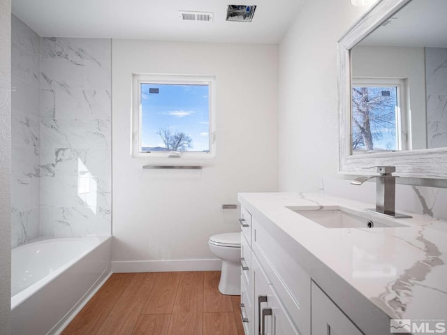 full bathroom featuring hardwood / wood-style floors, vanity, a healthy amount of sunlight, and toilet