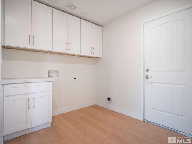 laundry area featuring cabinets, hookup for a washing machine, light hardwood / wood-style floors, and hookup for an electric dryer