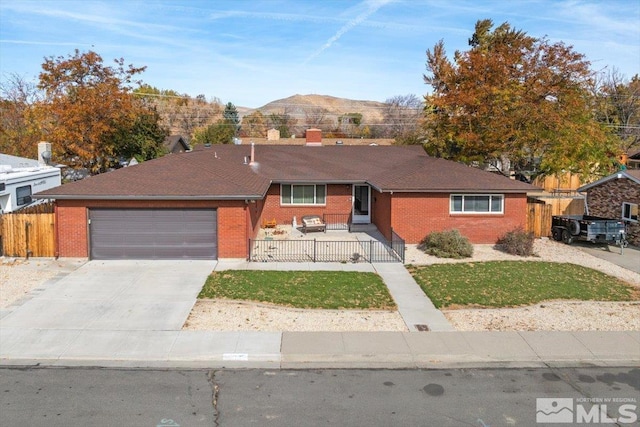 ranch-style home featuring a mountain view, a garage, and a front yard