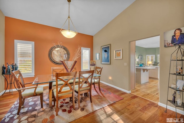 dining room featuring light wood-type flooring and lofted ceiling