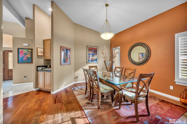 dining space featuring light hardwood / wood-style flooring and lofted ceiling