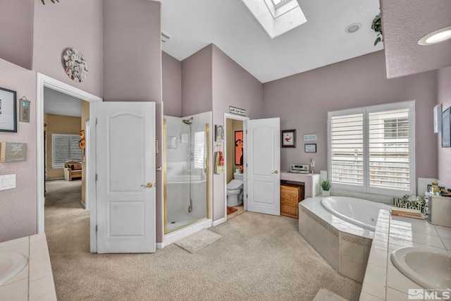 full bathroom with vanity, high vaulted ceiling, a skylight, toilet, and independent shower and bath