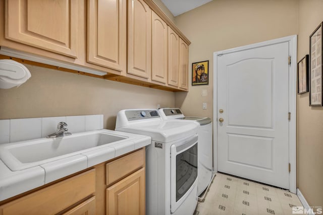 laundry area with washer and dryer, cabinets, and sink