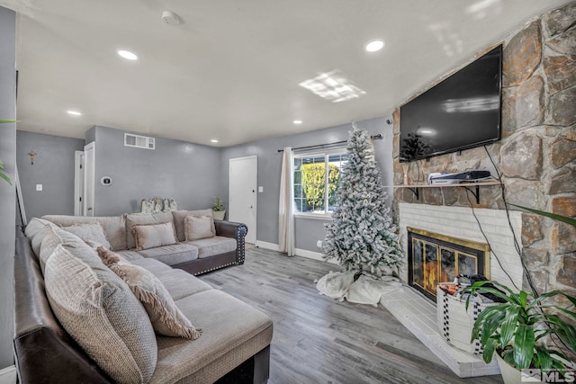 living room with hardwood / wood-style flooring and a brick fireplace