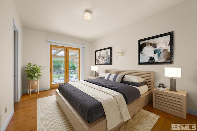 bedroom with access to exterior, french doors, and hardwood / wood-style flooring