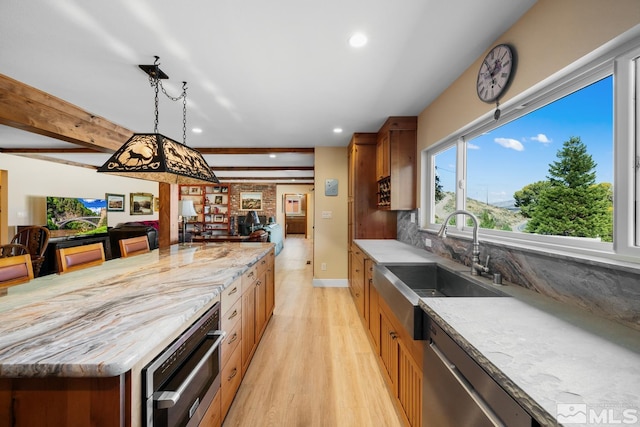 kitchen featuring light wood-type flooring, stainless steel appliances, sink, pendant lighting, and beamed ceiling