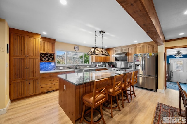 kitchen with beam ceiling, a center island, hanging light fixtures, stainless steel refrigerator with ice dispenser, and light hardwood / wood-style floors