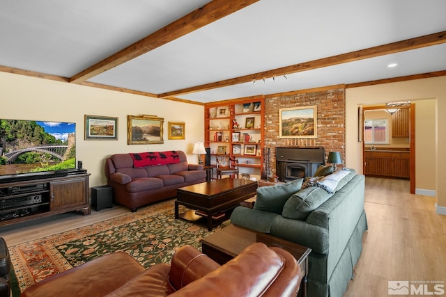 living room with light hardwood / wood-style flooring, beamed ceiling, and built in features