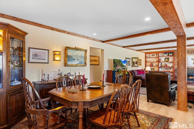 dining space with beam ceiling and light wood-type flooring