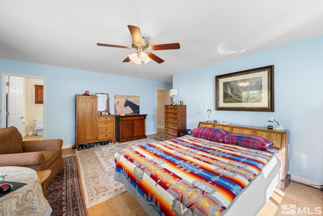 bedroom with ceiling fan, ensuite bathroom, and light hardwood / wood-style flooring