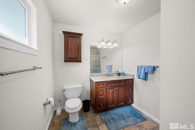 bathroom featuring vanity, toilet, and a shower with shower door