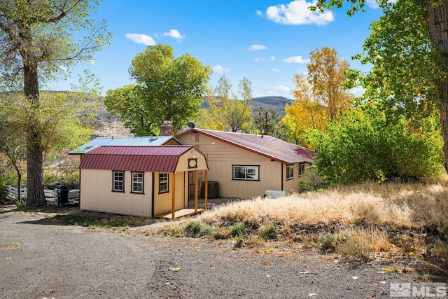 view of front of home with a mountain view and a shed