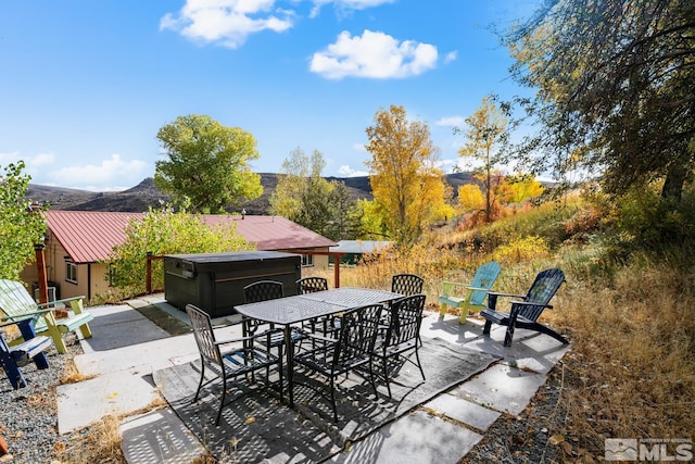 view of patio / terrace featuring a mountain view and a hot tub