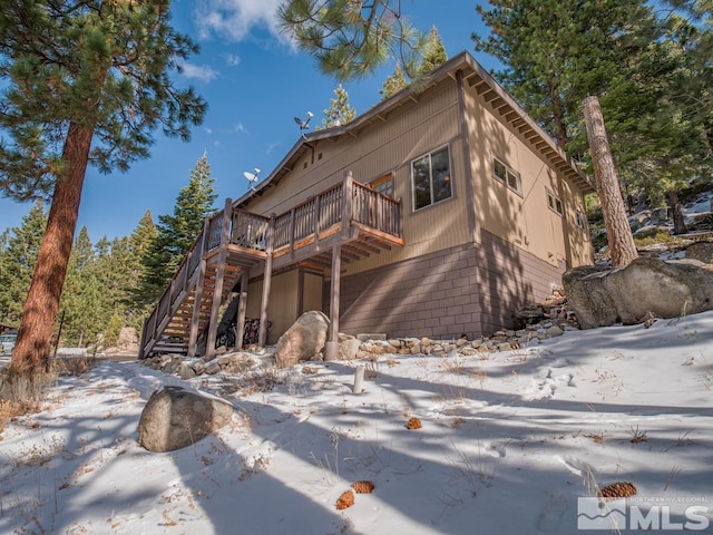 rustic home with a wooden deck and stairs