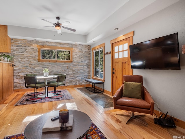 living area featuring light wood-type flooring and ceiling fan