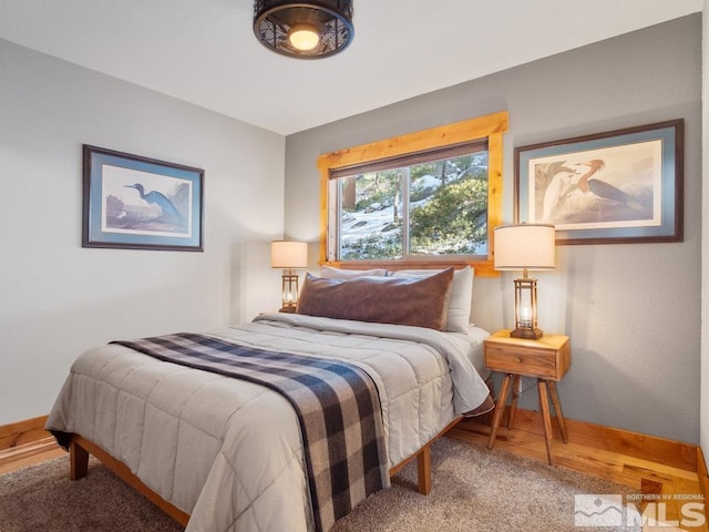 bedroom featuring baseboards and wood finished floors