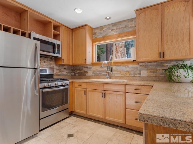 kitchen featuring open shelves, appliances with stainless steel finishes, a sink, and light brown cabinetry