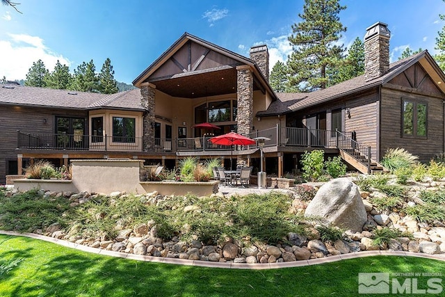 back of property featuring a patio area and a wooden deck