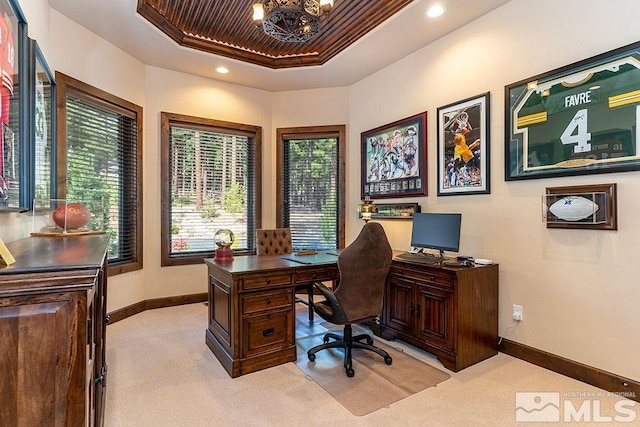 office with light carpet, an inviting chandelier, and a raised ceiling