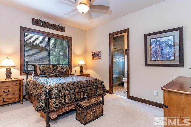 carpeted bedroom with ensuite bath and ceiling fan