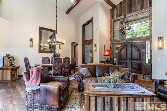 living room with hardwood / wood-style floors, high vaulted ceiling, beamed ceiling, and a notable chandelier