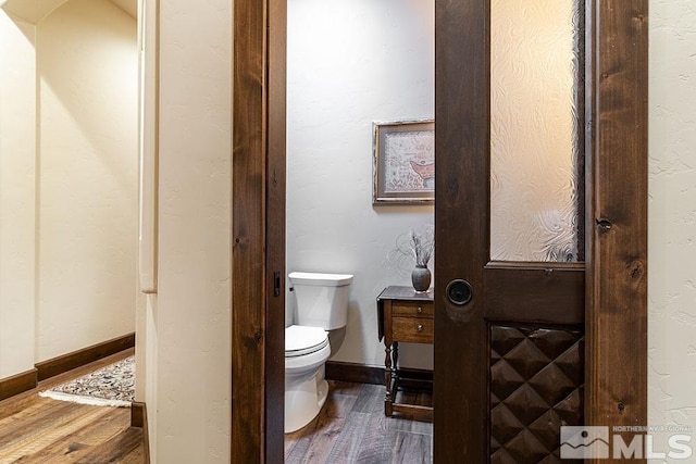 bathroom with hardwood / wood-style floors and toilet