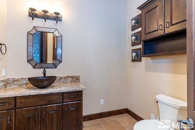 bathroom featuring toilet, vanity, and tile patterned floors