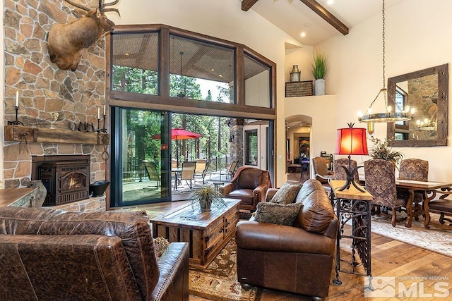 living room featuring a fireplace, beam ceiling, high vaulted ceiling, and wood-type flooring