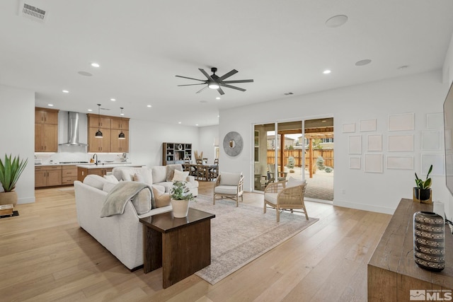 living room featuring ceiling fan and light hardwood / wood-style flooring