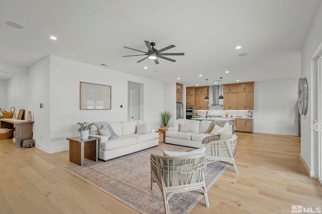 living room featuring ceiling fan and light hardwood / wood-style floors