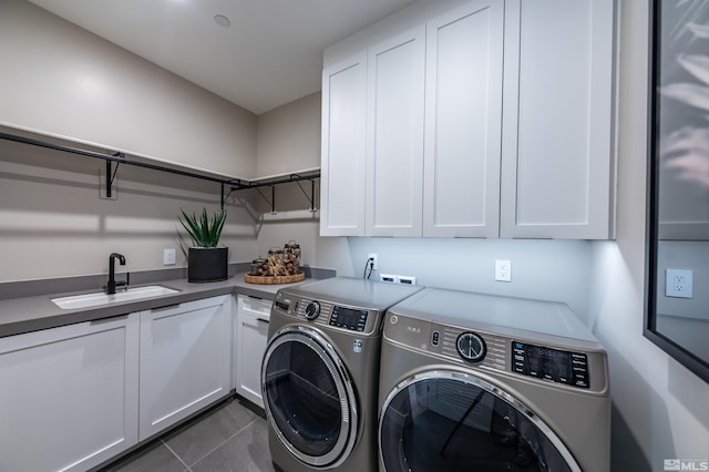 clothes washing area with washer and dryer, dark tile patterned flooring, cabinets, and sink