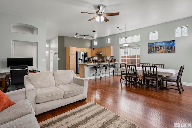 living room with dark hardwood / wood-style flooring and ceiling fan