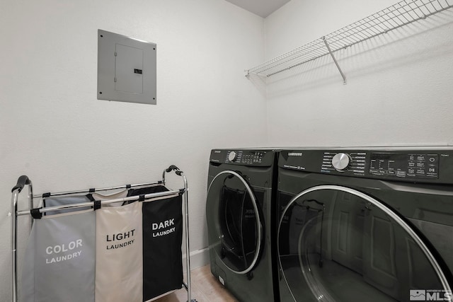 clothes washing area featuring electric panel, light hardwood / wood-style flooring, and independent washer and dryer