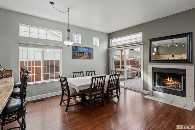 dining space featuring a fireplace and dark hardwood / wood-style floors