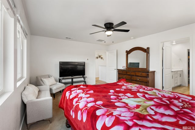 carpeted bedroom with ceiling fan and ensuite bathroom