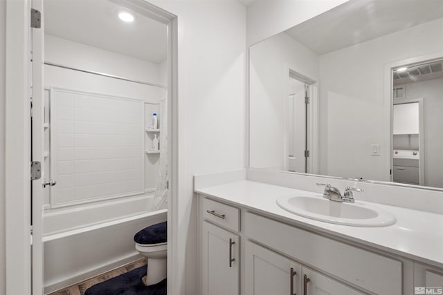 full bathroom featuring toilet, washer / dryer, vanity, and bathtub / shower combination