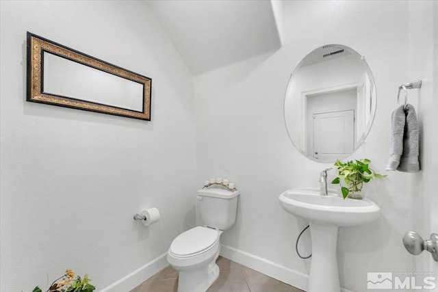 bathroom featuring tile patterned floors, vaulted ceiling, and toilet