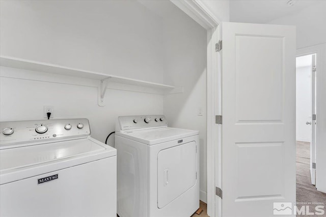 laundry room with washing machine and dryer and light colored carpet