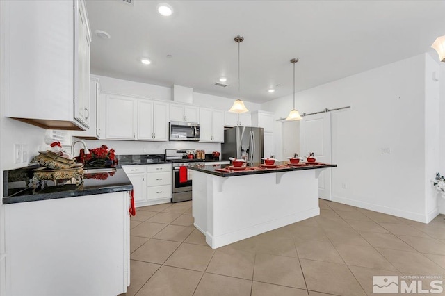 kitchen featuring appliances with stainless steel finishes, a center island, white cabinetry, and light tile patterned flooring