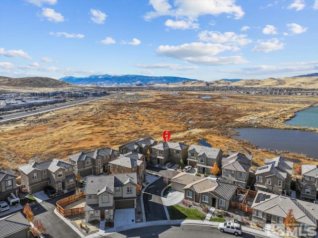 drone / aerial view with a water and mountain view