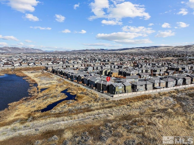 birds eye view of property with a water and mountain view