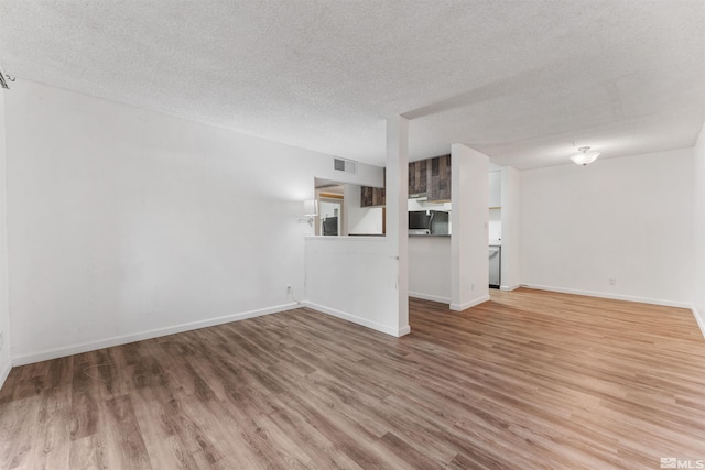 unfurnished living room featuring wood-type flooring and a textured ceiling