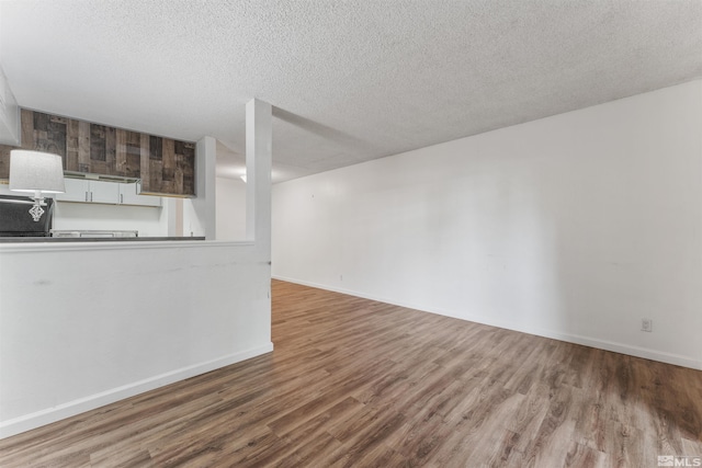 unfurnished living room with hardwood / wood-style floors and a textured ceiling