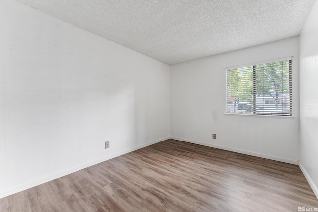 empty room featuring light hardwood / wood-style flooring and a textured ceiling