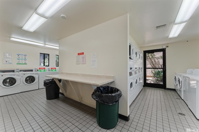 washroom with stacked washing maching and dryer, light tile patterned floors, and separate washer and dryer